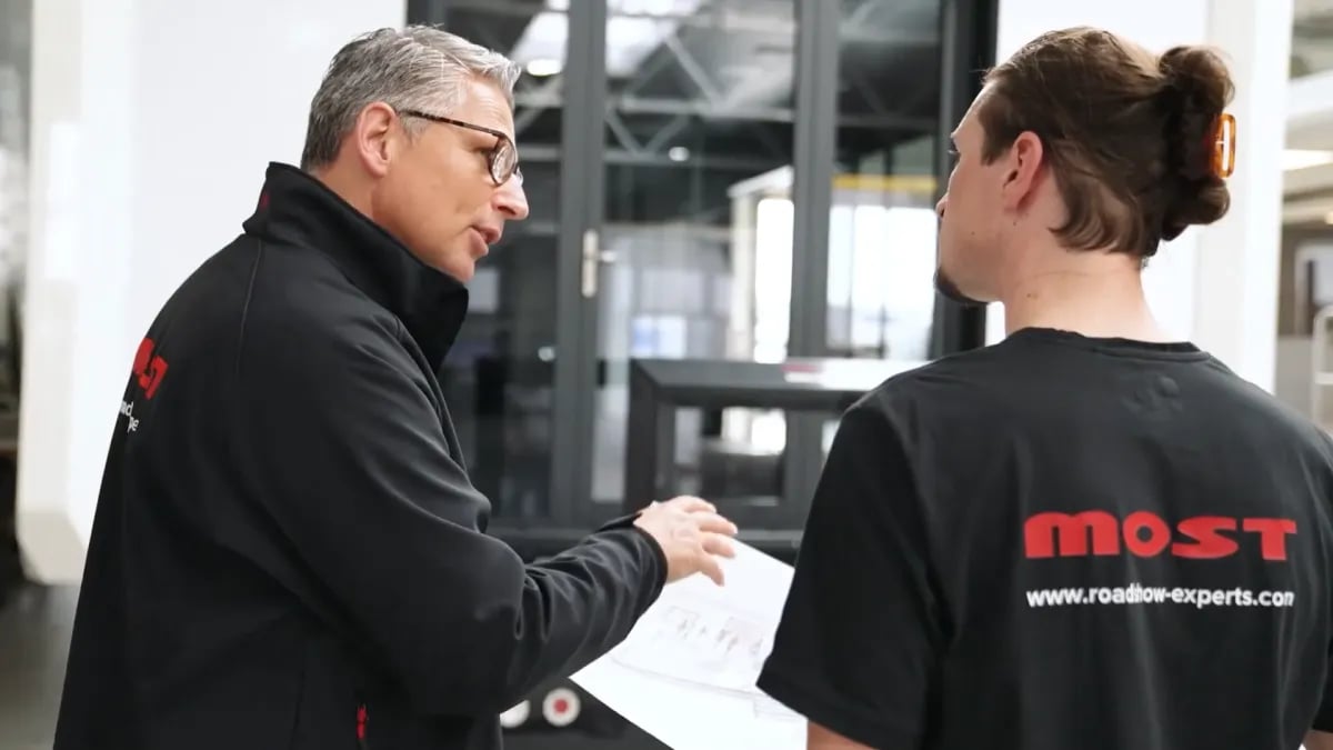 Two MOST employees discussing a plan in the hall
