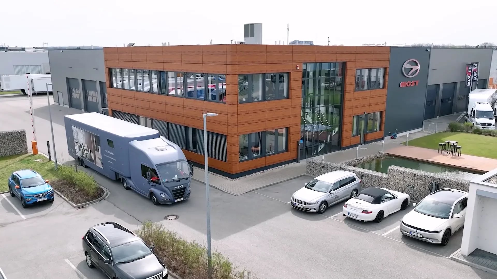 Firmensitz von MOST in Fürth aus der Luft, Bürogebäude, Halle und ein Showtruck auf dem Hof