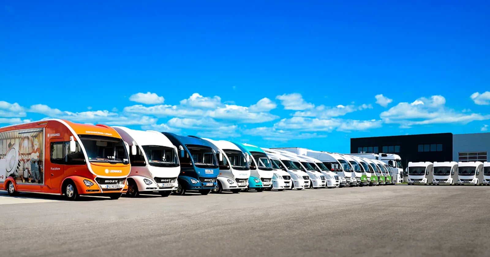 Lange Reihe von Showtrucks in verschiedenen Farben auf einem Hof