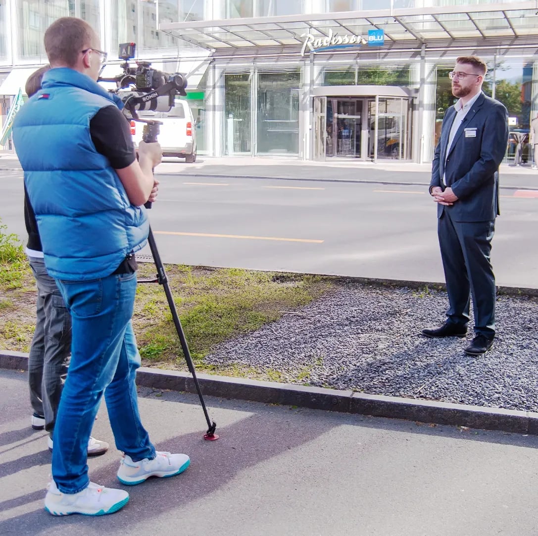 Kamerateam filmt ein Interview vor einem Hotel