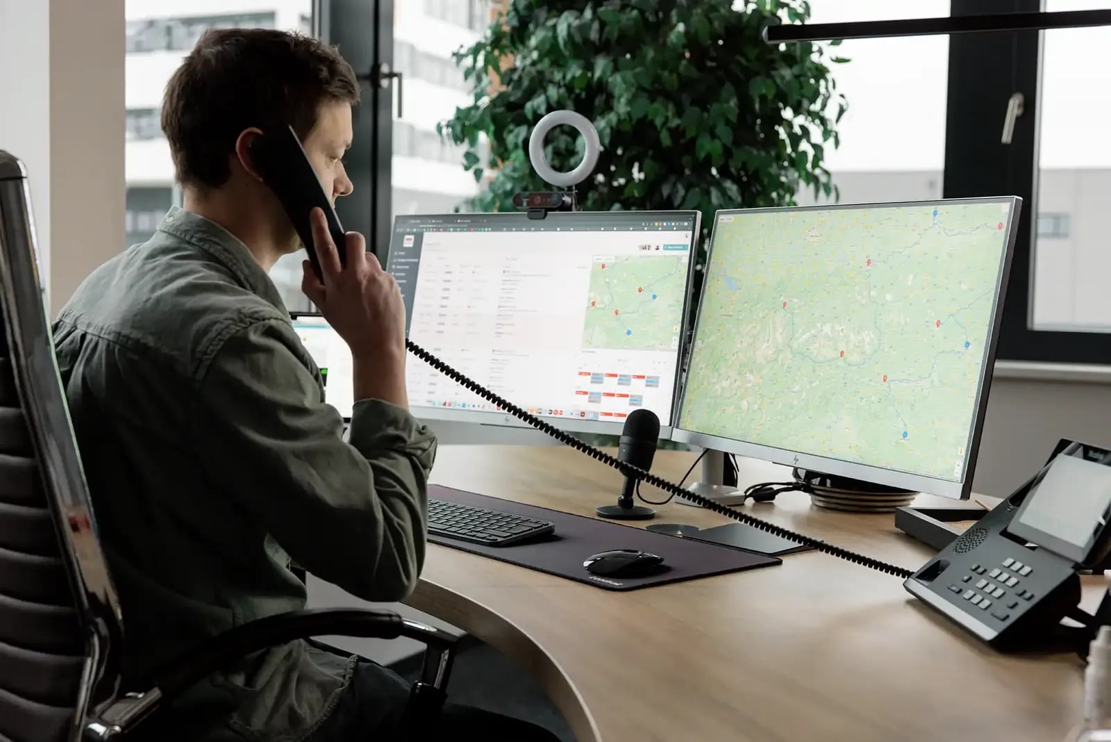 Disponent plant eine Tour am Telefon, Karten auf zwei Bildschirmen