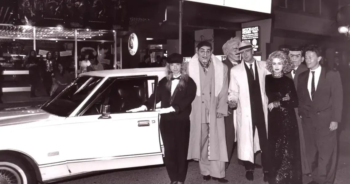 Schwarzweißfoto: Gäste in Abendgarderobe vor einer weißen Stretch-Limousine